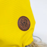 Yellow dog jacket with a brown leather patch featuring a dog logo on a white background