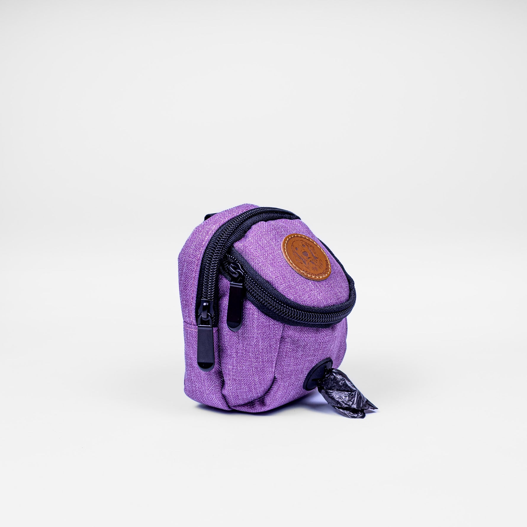 Purple dog waste bag dispenser with a brown leather patch on a white background
