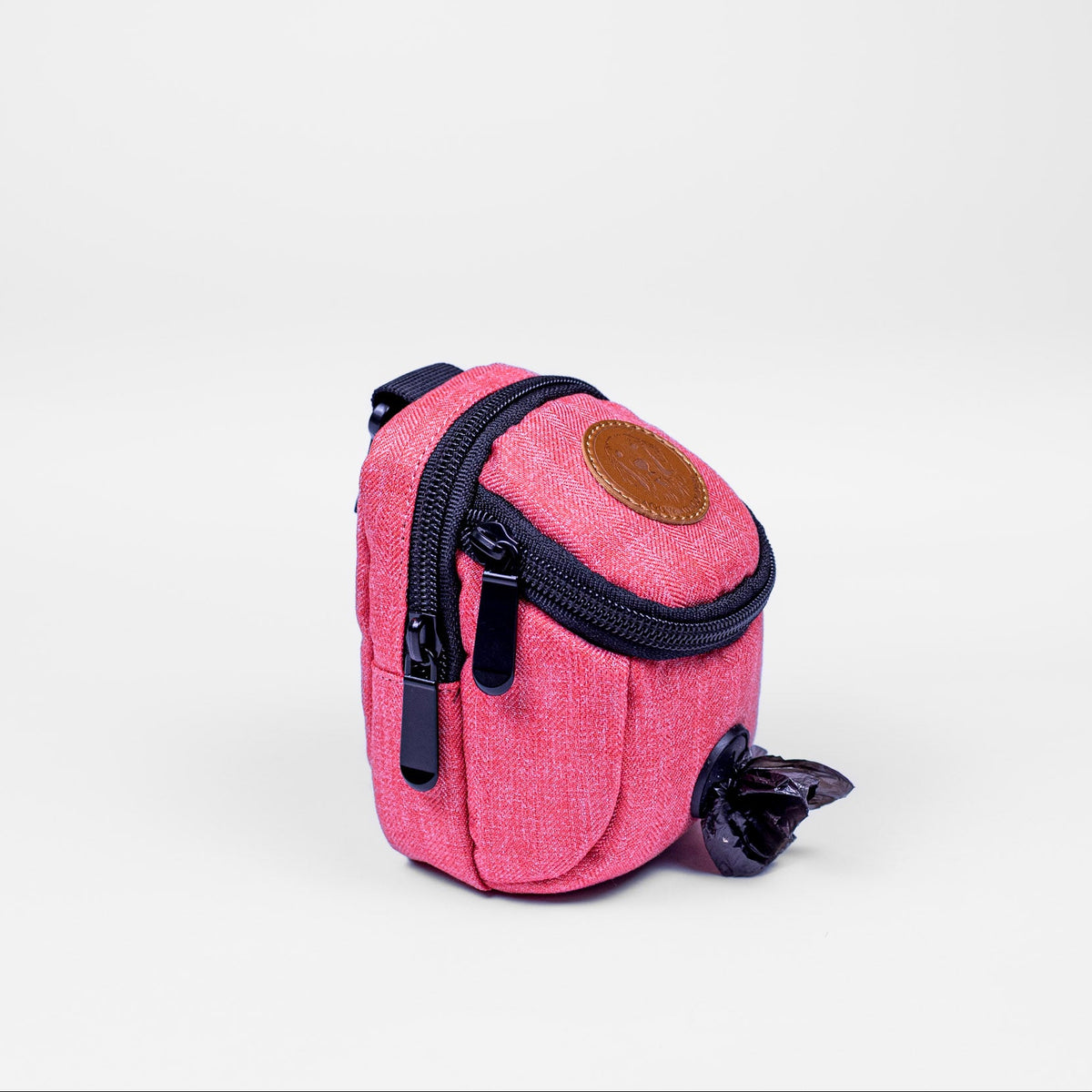 Pink dog waste bag dispenser with a black zipper on a white background