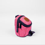 Pink dog waste bag dispenser with a black zipper on a white background