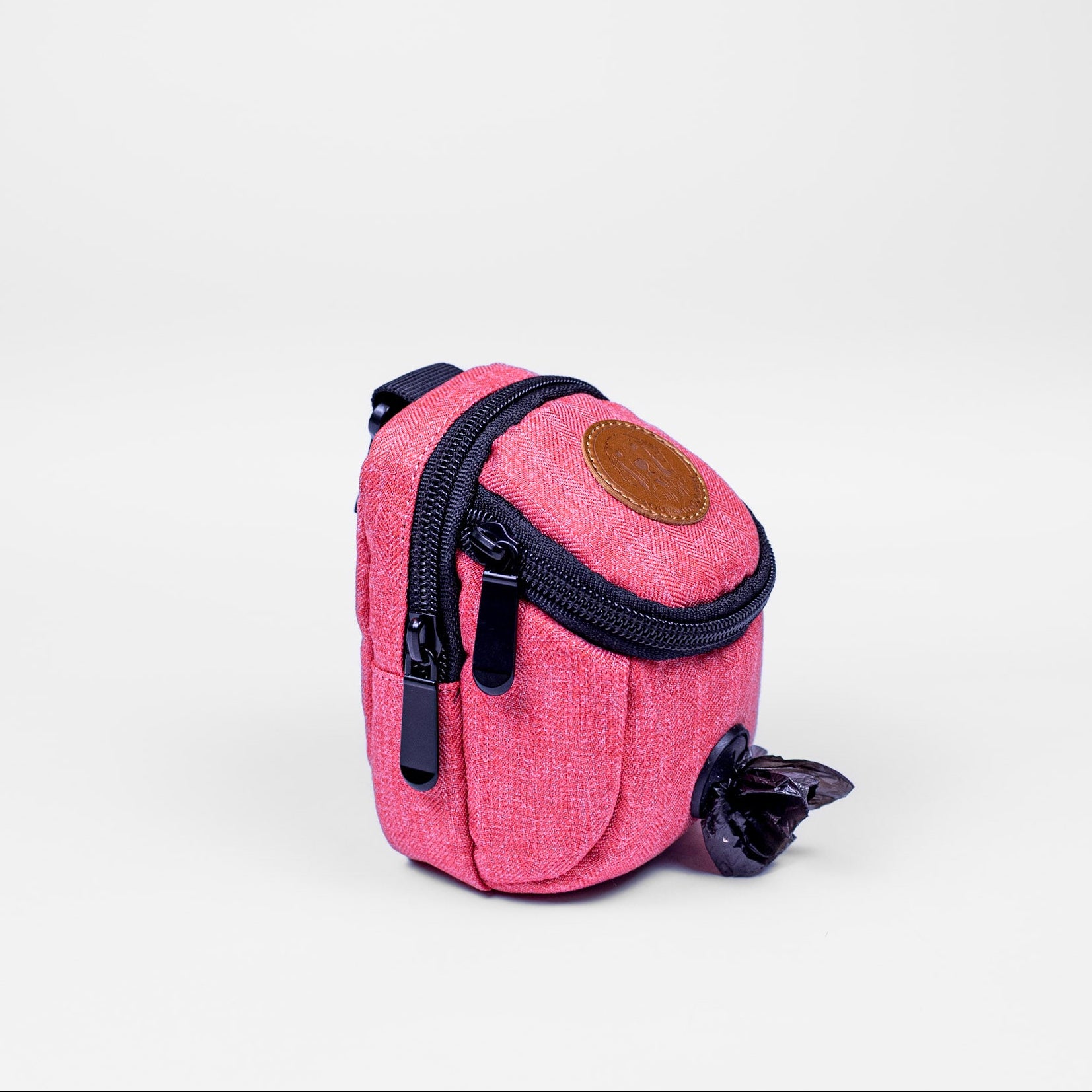 Pink dog waste bag dispenser with a black zipper on a white background